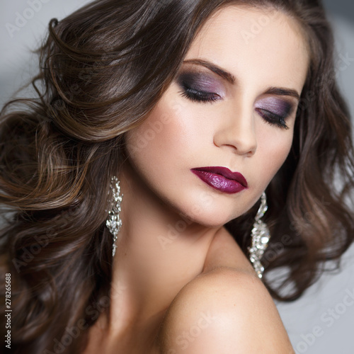Beauty portrait of a beautiful brunette girl with evening make-up.
