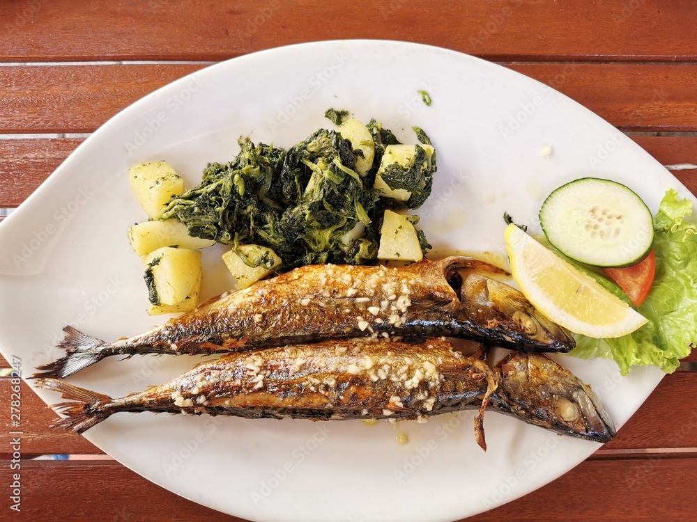 cooked mackerel fish meal with spinach on the top cooked mackerel fish meal with spinach on the top