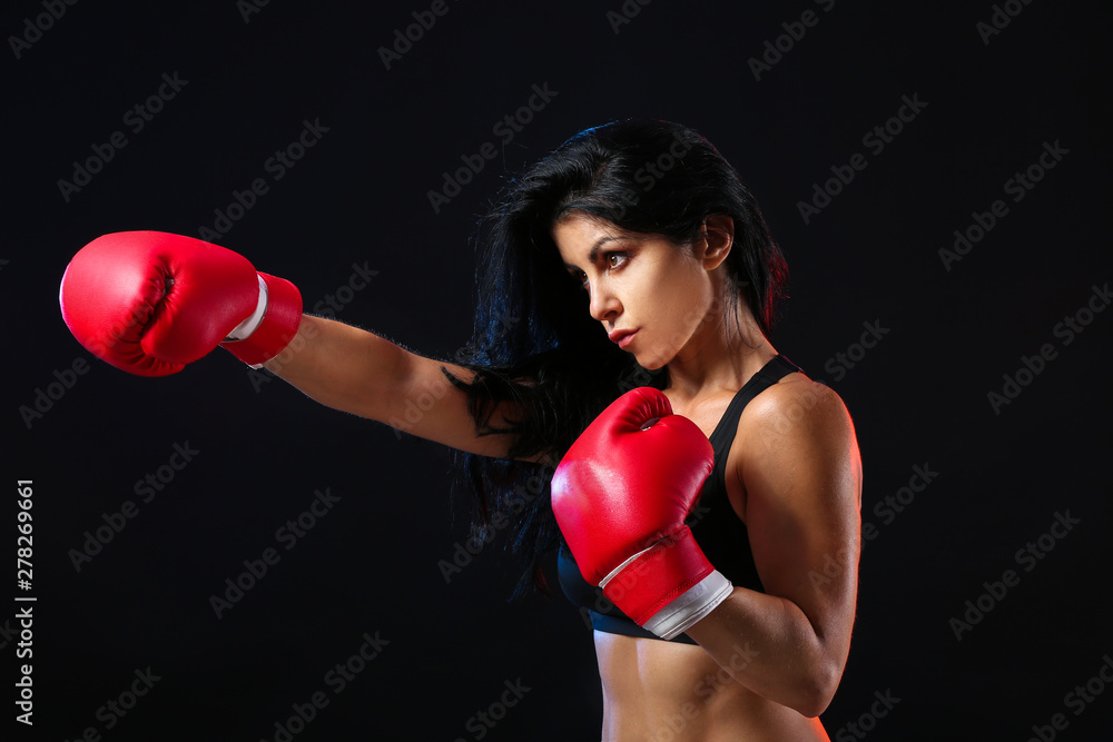 Sporty female boxer on dark background Sporty female boxer on dark background