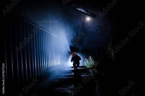 Horror scene of a scary children's ghost, Silhouette of scary baby doll on dark foggy background with light.