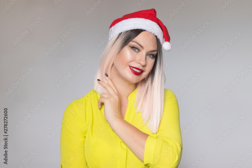 Studio portrait of a beautiful blonde woman wearing christmas red hat Studio portrait of a beautiful blonde woman wearing christmas red hat