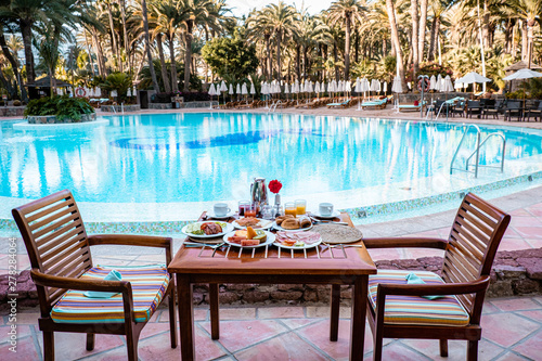 Φωτογραφία breakfast by swimming pool, fruit bread and coffee with orange juice by the pool