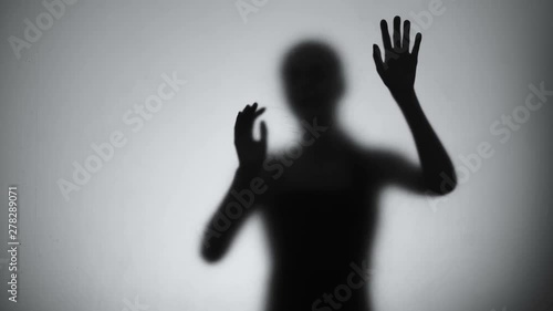 Silhouette of desperate woman crying behind glass, mental disorder, hysteric