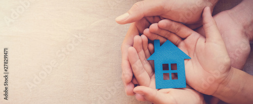 hands holding paper house, family home, homeless shelter, international day of families, foster home care, family day care, social distancing, stay at home, housing mortgage crisis concept