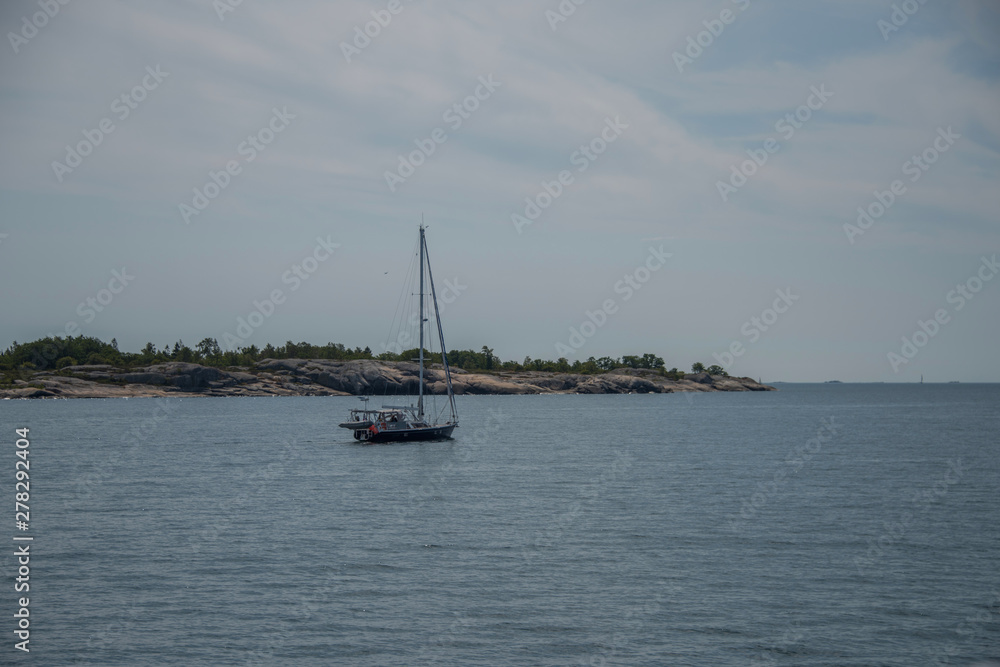 Sailing boats and the Stockholm northen archipelago a hazy summer day at the island Furusund and Yxlan