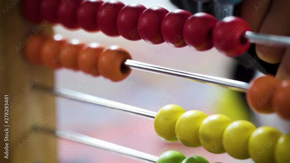 Young boy counting with a colourful abacus in slow motion