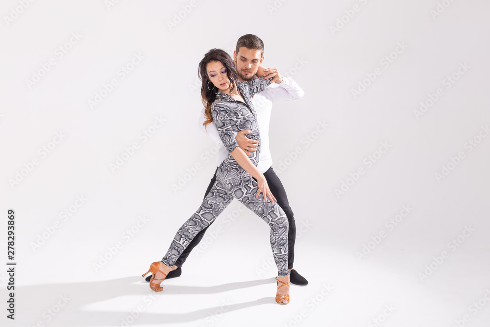 Skillful dancers performing in the white background with copy space. Sensual couple performing an artistic and emotional contemporary dance Skillful dancers performing in the white background with copy space. Sensual couple performing an artistic and emotional contemporary dance