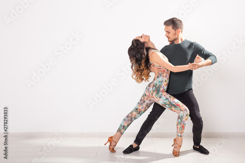 Fototapeta Naklejka Na Ścianę i Meble -  Social dance concept - Active happy adults dancing bachata together over white background with copy space