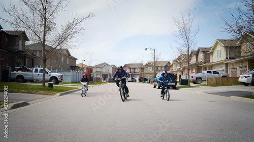 Wallpaper Mural Three young boys riding their bikes down the street in slow motion Torontodigital.ca