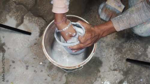 Close up of indian worker mixin paint with his hands. photo