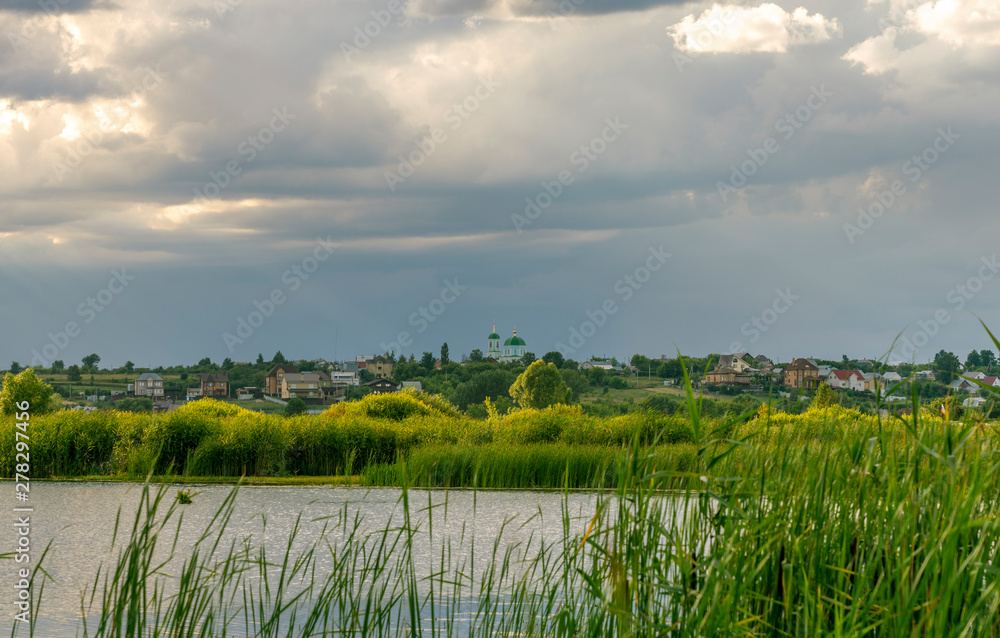 sunset sky over the river, in the background a village with a Church sunset sky over the river, in the background a village with a Church