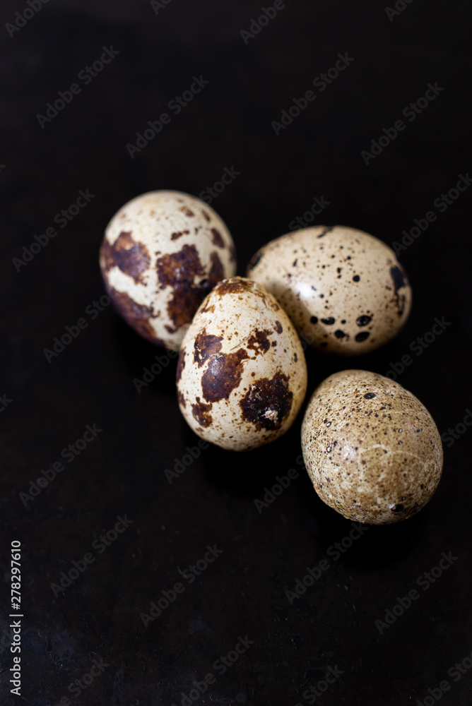 Obraz premium composition with small quail eggs in the bowl on the black wooden background