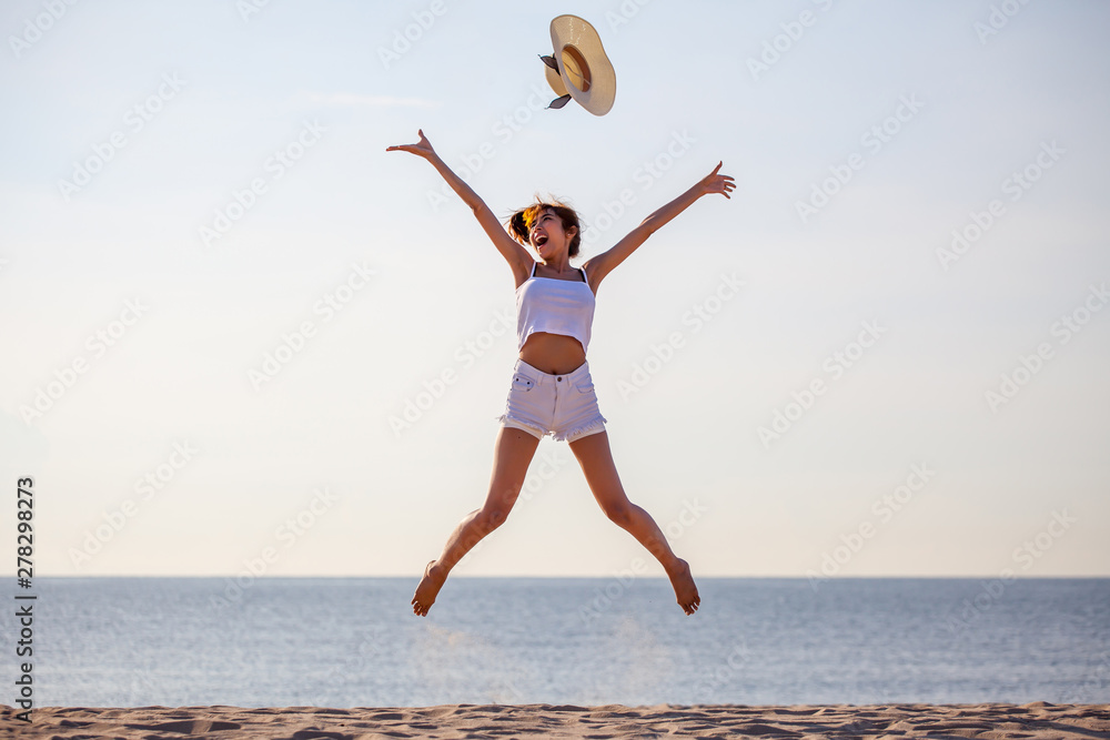 beautiful young asian woman excited throwing hats up on the air at the sea beach . Happy girl enjoy holidays vacation . success . winner .outdoors beautiful young asian woman excited throwing hats up on the air at the sea beach . Happy girl enjoy holidays vacation . success . winner .outdoors