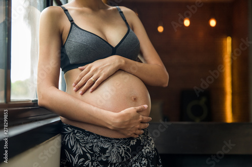 Portrait of a mother to be holding her belly photo