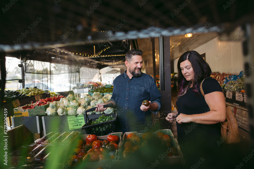 Couple enjoying doing groceries together at local market Couple enjoying doing groceries together at local market