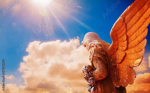 Fotografija Ancient statue of guardian angel in sunlight as a symbol of strength, truth and faith