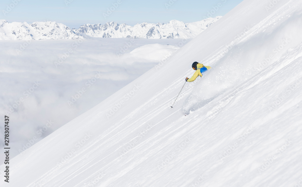 Skier moving down the slope on fresh snow Skier moving down the slope on fresh snow