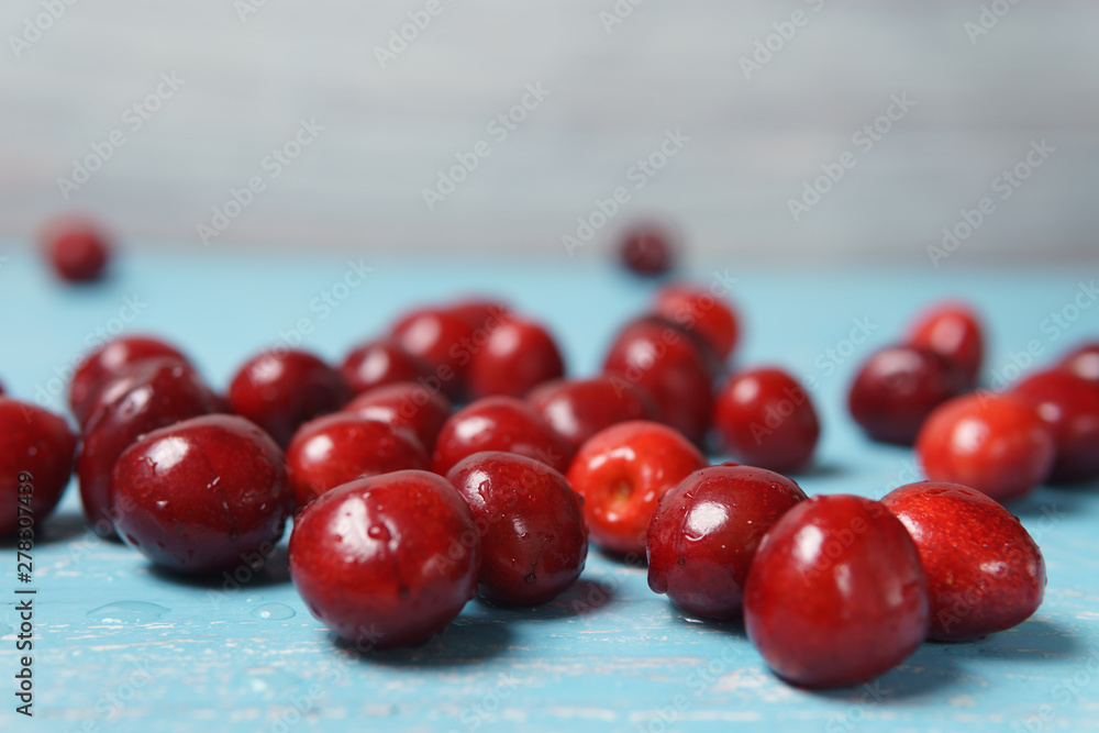 Red sweet cherry scattered on a turquoise wooden table Red sweet cherry scattered on a turquoise wooden table