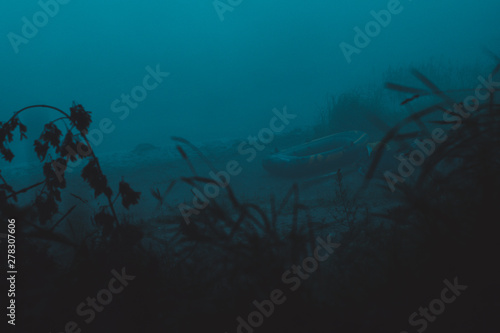 Fototapeta Naklejka Na Ścianę i Meble -  Fisherman's boat in the fog on the beach