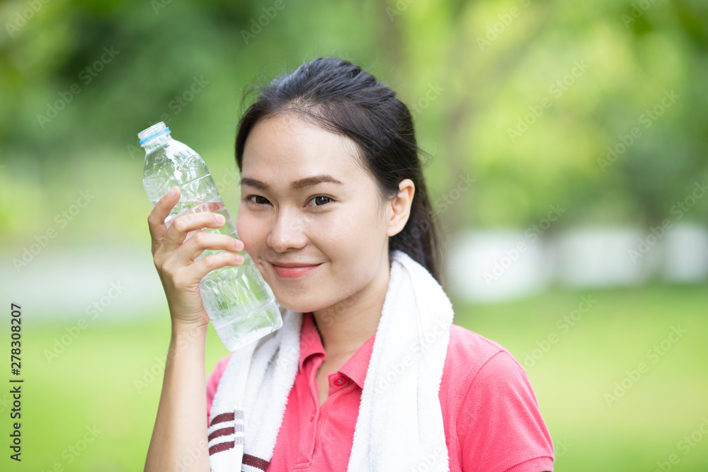 sporty asian woman drinking water from a bottle after jogging or running, sport and healthy concept sporty asian woman drinking water from a bottle after jogging or running, sport and healthy concept