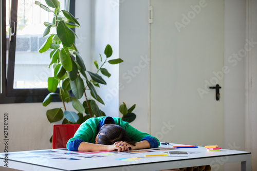 Exhausted Executive Lying With Head Down On Table photo