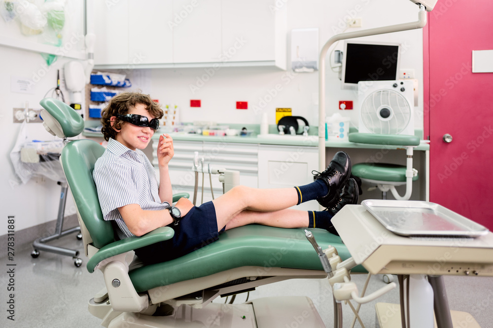 School boy waiting for treatment in a dentist chair School boy waiting for treatment in a dentist chair