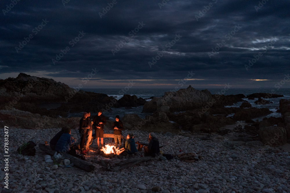 Friends around a beach campfire. Friends around a beach campfire.