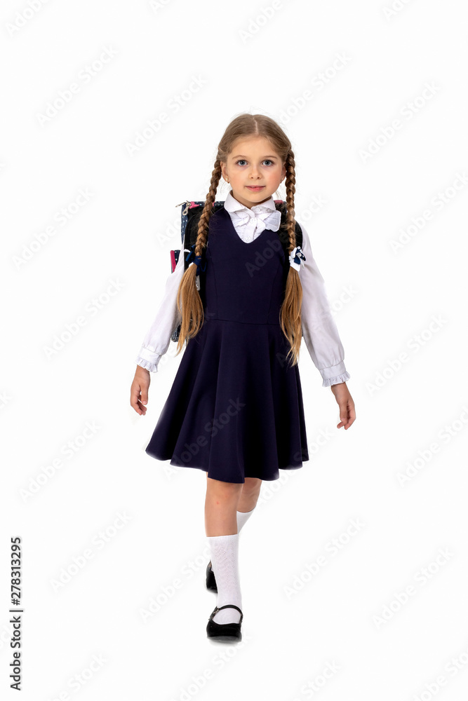 little girl seven years posing in school uniform and backpack on white isolated background .Girl preparing for school little girl seven years posing in school uniform and backpack on white isolated background .Girl preparing for school