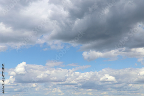 Blue sky texture background with white fluffy clouds. Horizontal, nobody, place for text. The concept of nature and meteorology.
