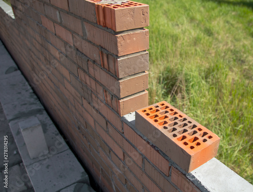 Brick laying in the wall at a construction site at home
