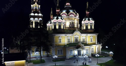 Bright Church with Golden domes and crosses. Glows in the night Park. Drone footage. Top and side view. Evening Cathedral in the Park. Bright temple. Modern design of the old building. Lots of lights.