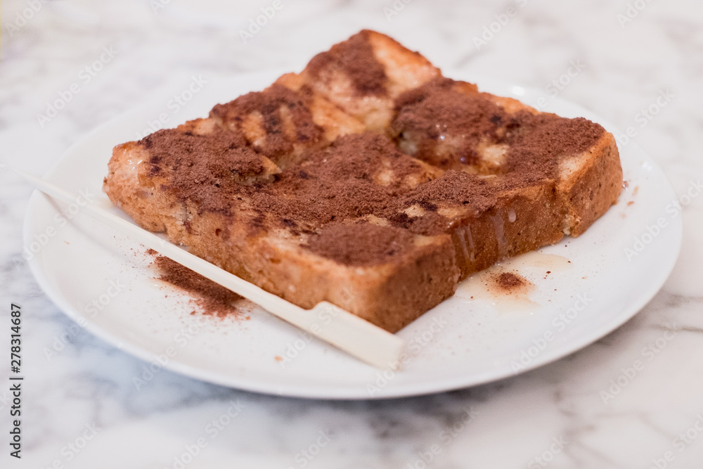 Focus on toast, sprinkle with delicious Ovaltine. On the marble table Focus on toast, sprinkle with delicious Ovaltine. On the marble table