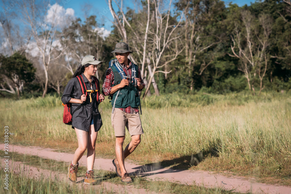 Happy young couple walking hiking in forest for camping tent together Happy young couple walking hiking in forest for camping tent together