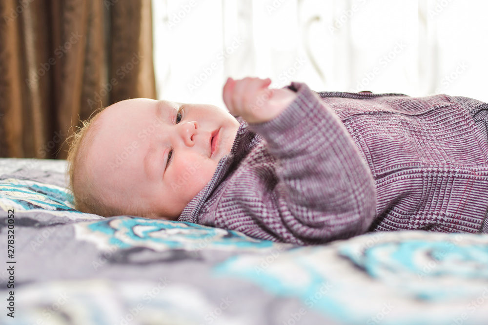 Newborn child relaxing in bed. Nursery for children. Textile and bedding for kids. Family morning at home. New born kid during tummy time with toy bear Newborn child relaxing in bed. Nursery for children. Textile and bedding for kids. Family morning at home. New born kid during tummy time with toy bear