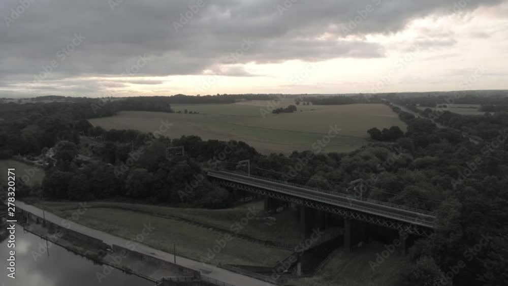 Sunrise storm clouds over reservoir railway bridge. UK. Aerial rising pull back reveal. Sunrise storm clouds over reservoir railway bridge. UK. Aerial rising pull back reveal.