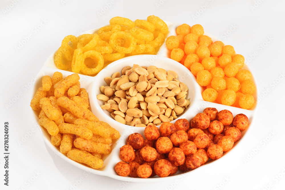 Mix of snacks on a white plate isolated on white. Mix of snacks on a white plate isolated on white.
