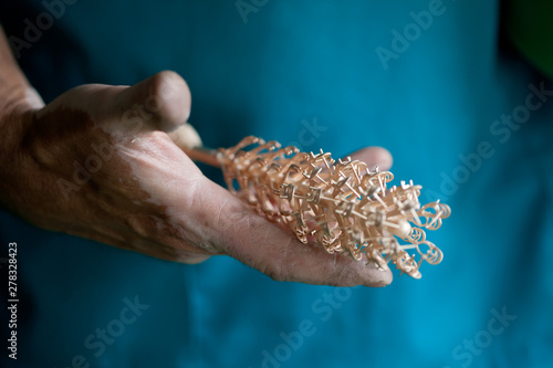 hands holding cast golden parts for jewelry