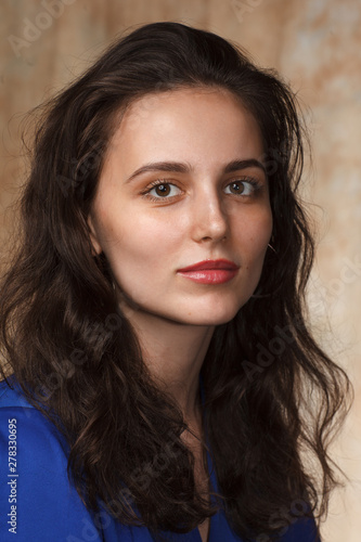 close up portrait of young cheerful brunette caucasian woman on beige background, angle three quarter