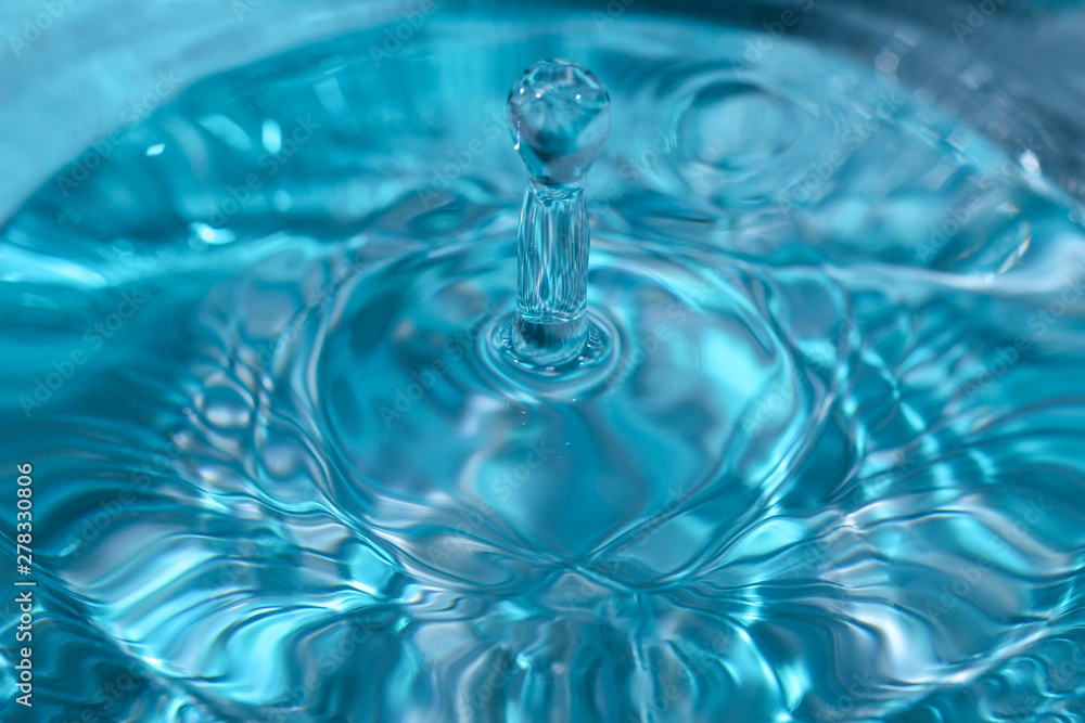 Fallender Wassertropfen mit blauem Hintergrund Fallender Wassertropfen mit blauem Hintergrund