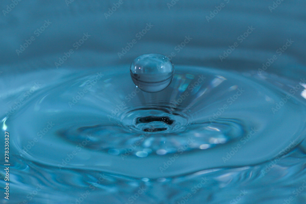Wasserskulptur aus eingetauchtem Wassertropfen mit blauem Hintergrund