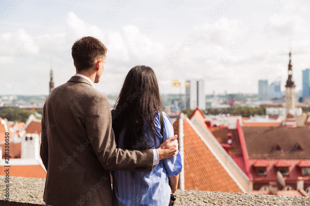 Back view of the happy couple who is looking at the city