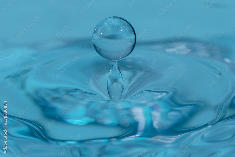 Fallender Wassertropfen mit blauem Hintergrund Fallender Wassertropfen mit blauem Hintergrund