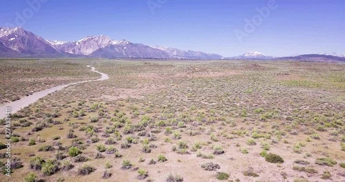 Whitmore Hot Springs ascending drone shot above campsite with tents, breathtaking landscape view with mountain range in the background photo