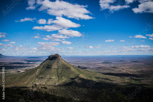 Mountain in the Valley of Desolation in Matjiesfontein, Graaf-Reinet, South Africa - with Rich Blue Sky and White Clouds Shadowing The Valley.