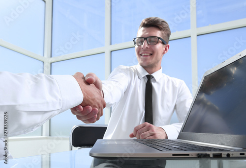 Satisfied entrepreneurs shaking hands after negotiations on meeting in office