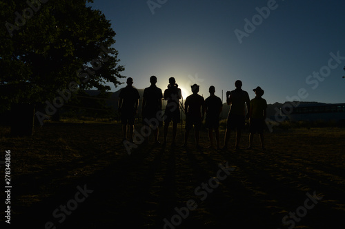 Team of Hikers in the Mountains Standing Ready at Sunrise as Silhouettes