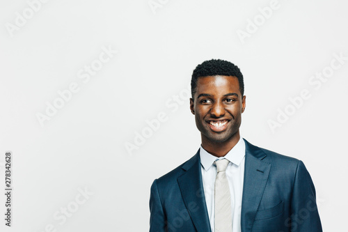 Canvas Print Portrait of a smiling, happy man in suit and tie looking to the side, isolated o