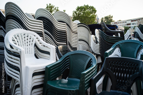 Stacks of plastic outdoor chairs placed in a public square in a city in Romania.