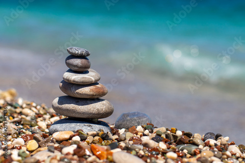 Pyramid of stones on pebble beach near the ocean. Obo from pebbles. Stone tower on the beach. Balance  peace of mind.