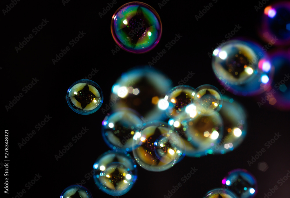 beautiful rainbow colorful of soap bubbles floating on black background.